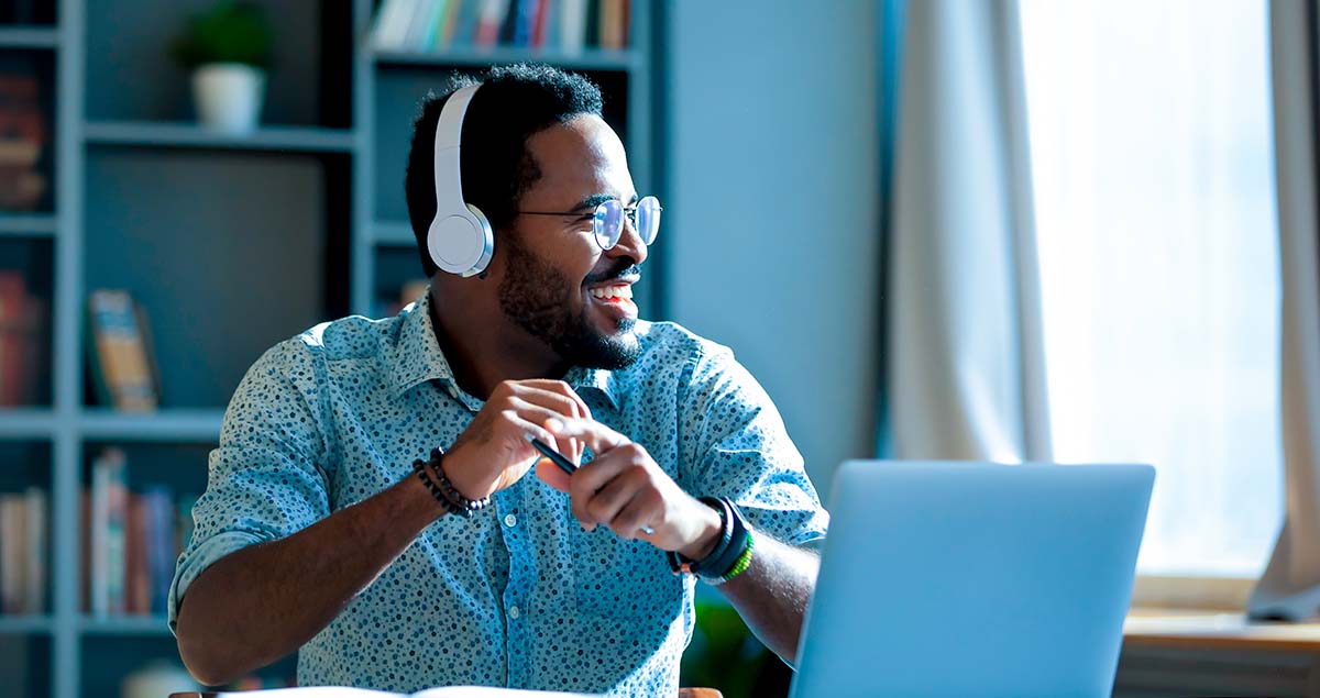 O que ESG? Como impacta o mundo e os investimentos? 1 Homem em frente a computador olhando para o lado e sorrindo