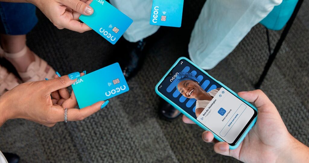 Mãos segurando celular com tela mostrando app Neon e demais segurando cartão Neon