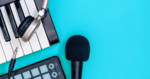 Microfone, teclado e fone de ouvido em primeiro plano com fundo azul