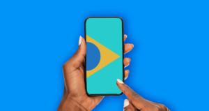 Mão segurando celular com bandeira do Brasil na tela
