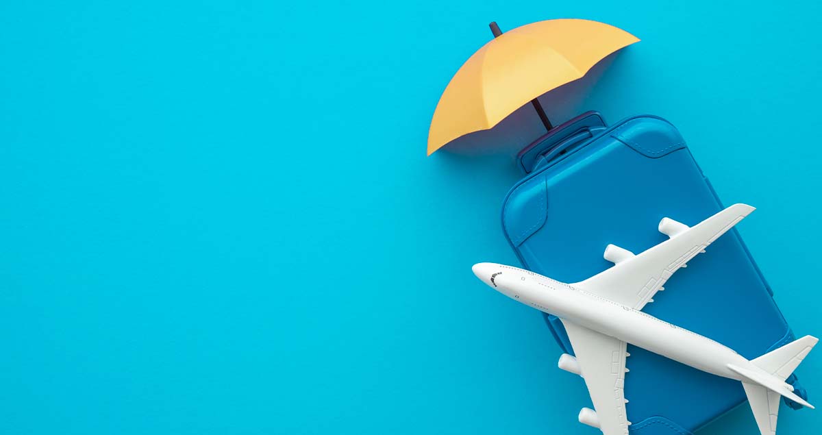 Destinos baratos para aproveitar as férias no mês de fevereiro 1 Avião de brinquedo sobre pequena mala com guarda-sol atrás