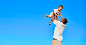 Homem segurando criança no alto