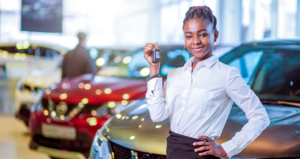 Mulher em concessionária segurando chave de carro