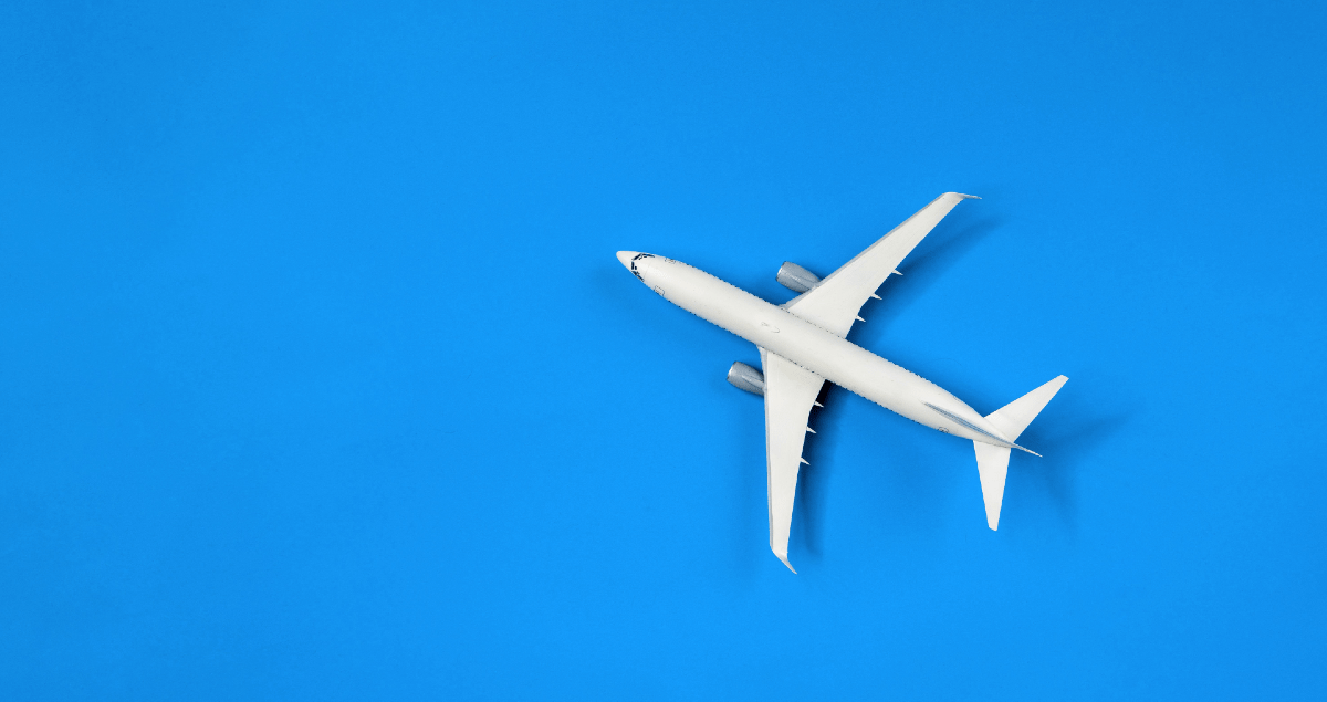 Avião branco de brinquedo sobre fundo azul