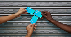 Três mãos segurando três cartões de crédito Neon
