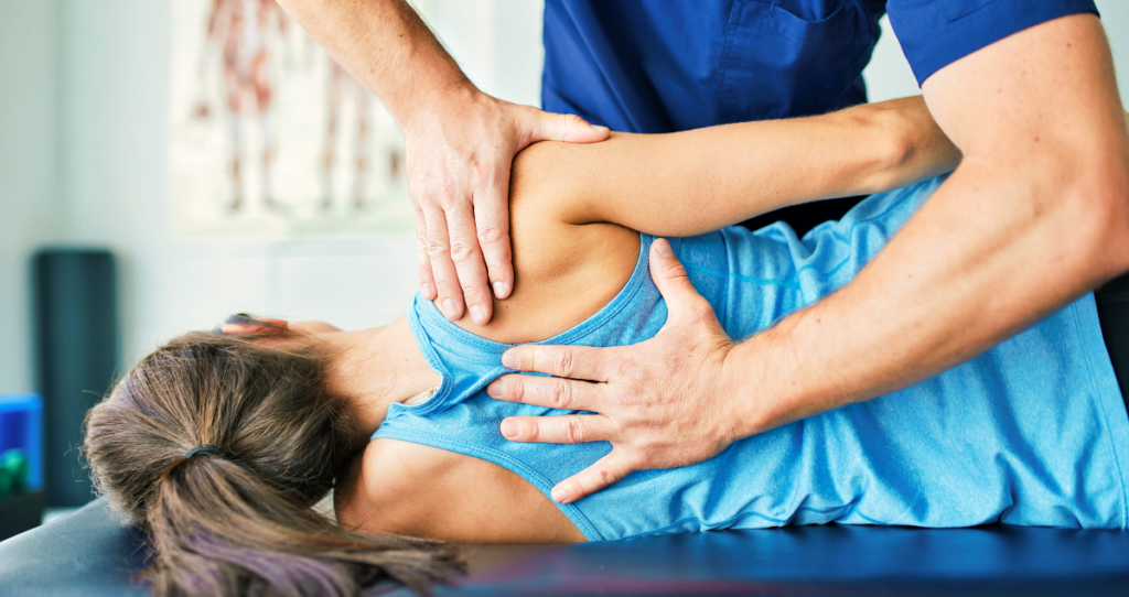 Pessoa deitada de costas em maca e fisioterapeuta com as mãos apoiadas nas costas dela