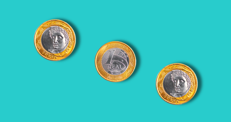 Três moedas de um real enfileiradas na diagonal