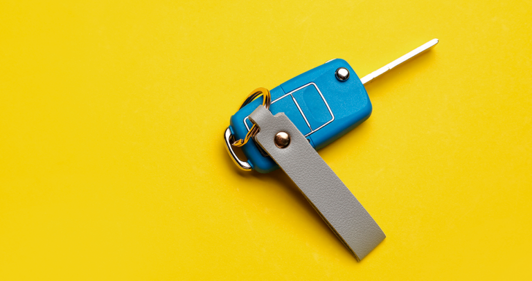 Chave de carro em cima de fundo amarelo