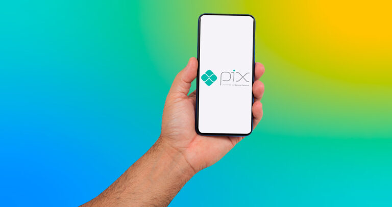 Mão segurando celular com logo do Pix