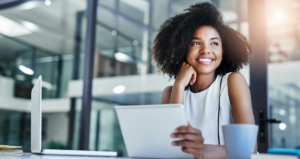 Mulher sorrindo olhando para o lado em frente a computador