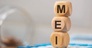 Cubos de madeira com cada peça com uma letra formando a palavra "MEI"
