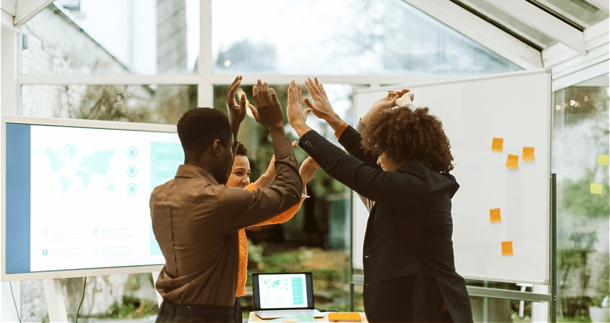 Pessoas com os braços para cima em escritório