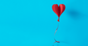 Balão em formato de coração em frente a fundo azul