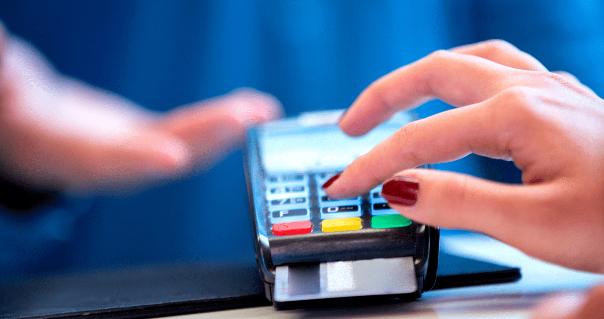 Pessoa digitando senha em maquininha