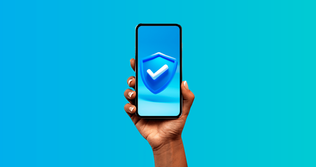 Pessoa segurando celular com símbolo de segurança na tela