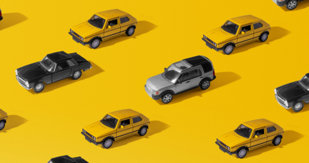 Carrinhos em miniatura em frente a fundo amarelo