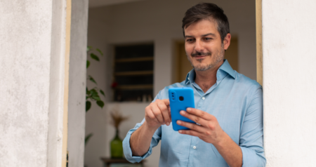 Homem sorrindo mexendo no celular