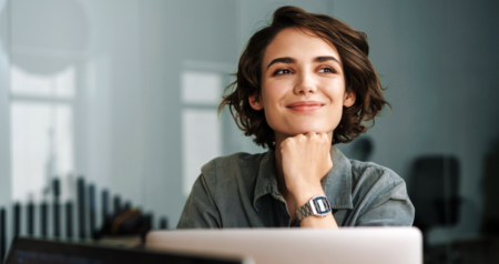 Mulher sorrindo em frente a computador