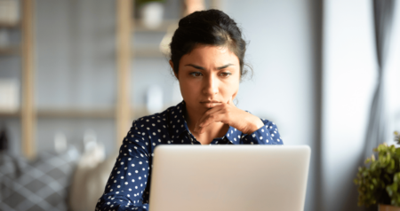 Mulher séria em frente a computador