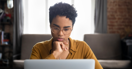 Mulher olhando para computador com olhar de dúvida