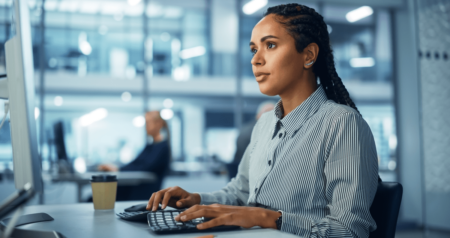 Mulher digitando em teclado de computador em escritório