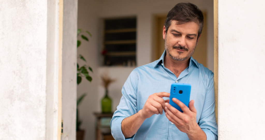 Homem mexendo em celular azul