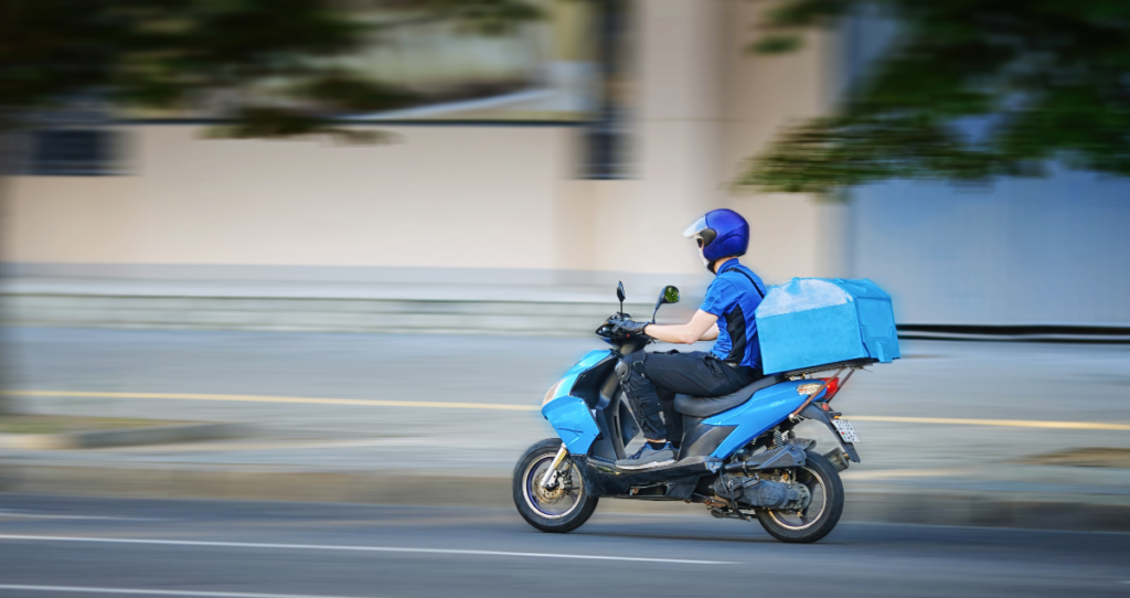 Motociclista em moto azul andando em cidade