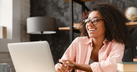 Mulher sorrindo em frente a computador