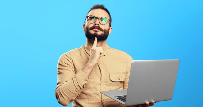Homem pensativo segurando notebook nas mãos em frente a fundo azul