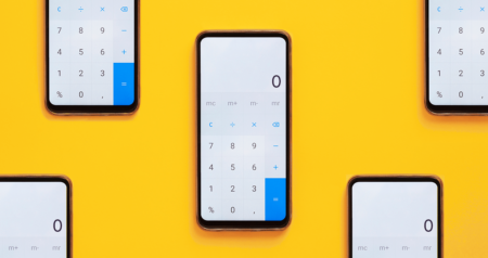 Celulares com calculadora aberta em frente a fundo amarelo