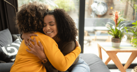 Duas mulheres se abraçando em sala