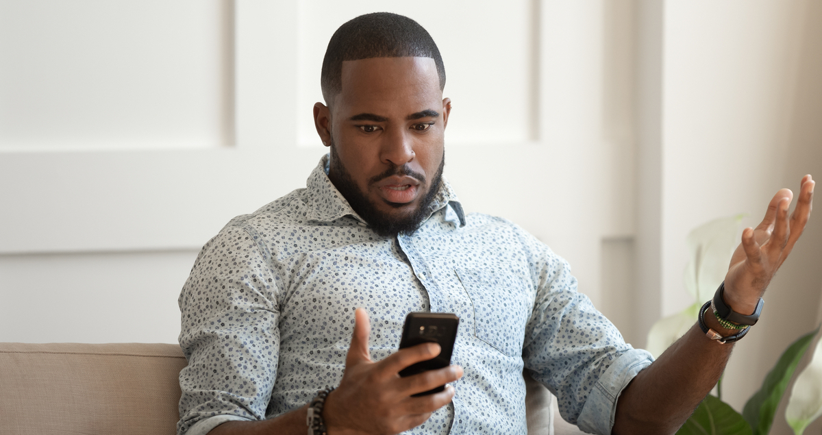 Homem olhando preocupado para celular